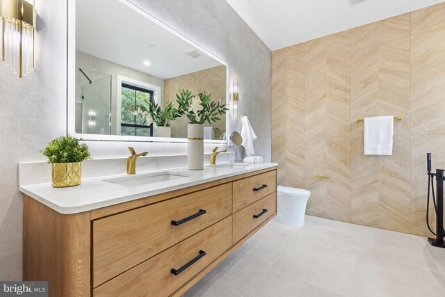 8206 Grubb Rd, Chevy Chase, MD 20815 - bathroom featuring tile walls, toilet, double vanity, a shower, and tile patterned flooring