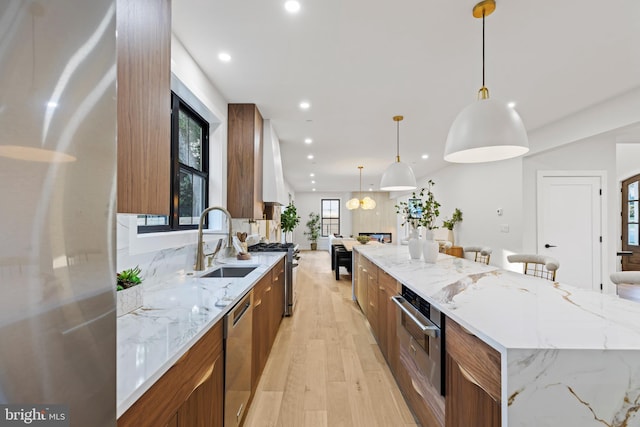 8206 Grubb Rd, Chevy Chase, MD 20815 - kitchen featuring modern cabinets, a sink, appliances with stainless steel finishes, brown cabinetry, and a spacious island