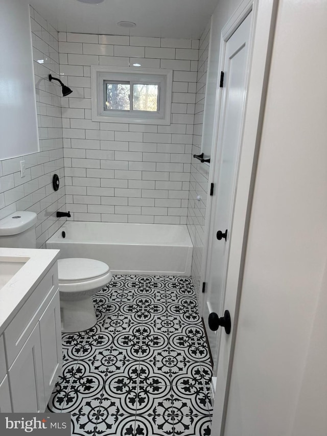 full bathroom featuring tile patterned flooring, vanity, toilet, and tiled shower / bath combo