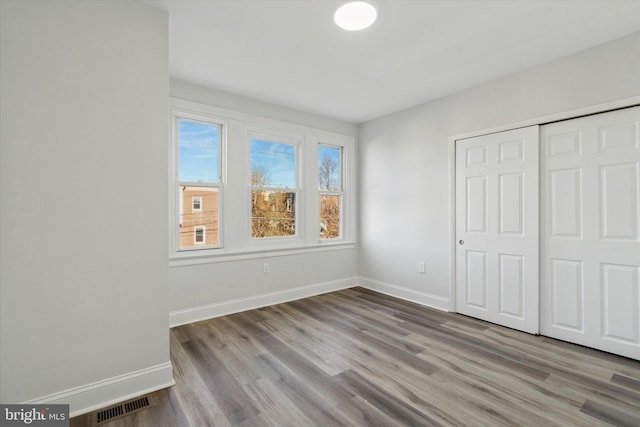 unfurnished bedroom featuring light wood-type flooring and a closet