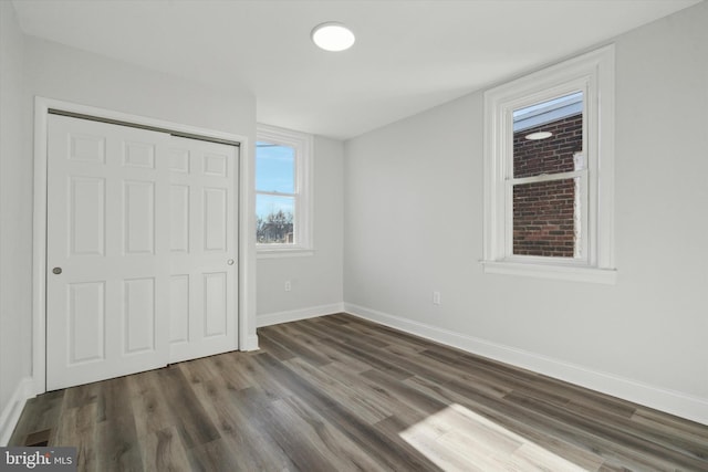 unfurnished bedroom with a closet and dark hardwood / wood-style floors