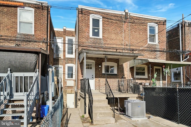 rear view of property with covered porch and central AC unit