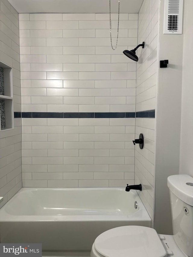 bathroom featuring tiled shower / bath and toilet