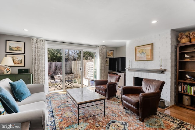 living room with light wood-type flooring and a fireplace