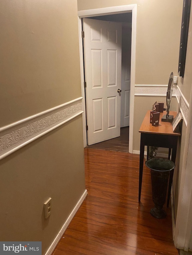 hallway with dark hardwood / wood-style flooring