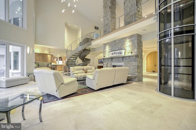 living room with a towering ceiling and a stone fireplace