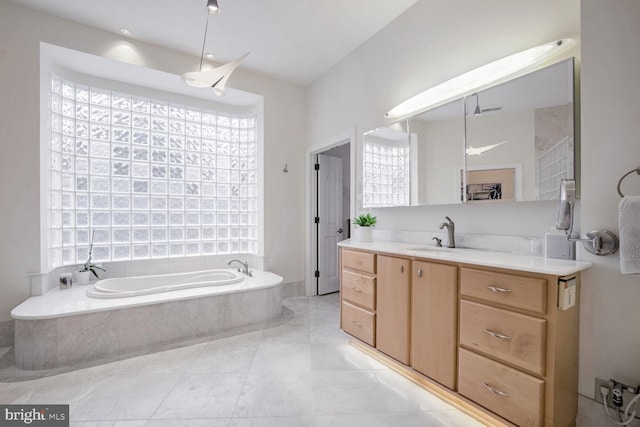 bathroom with vanity and tiled bath