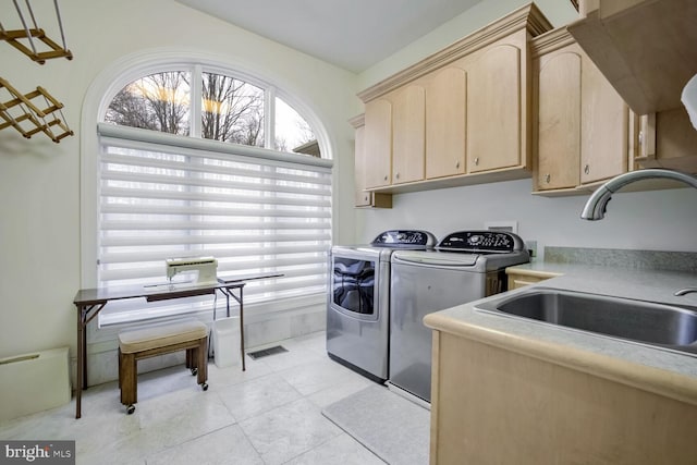 laundry area featuring cabinets, washing machine and dryer, and sink