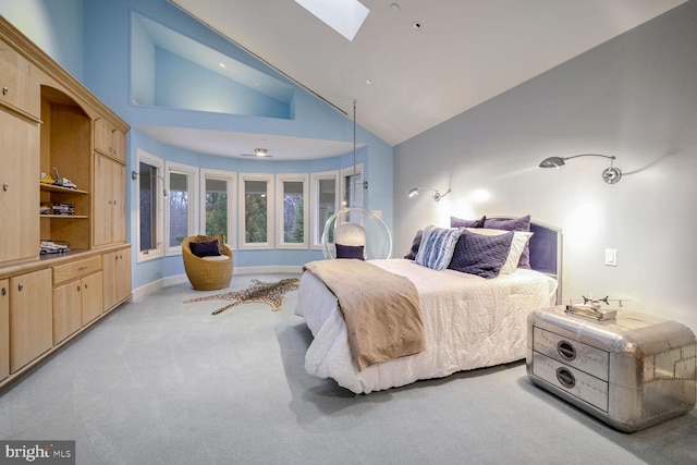 bedroom featuring a skylight, light carpet, and high vaulted ceiling