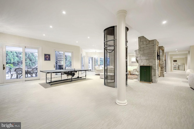 game room with light carpet, decorative columns, and a fireplace