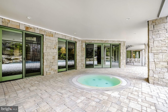 view of swimming pool with a hot tub