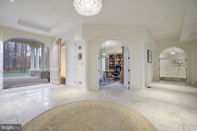 entryway with a raised ceiling and an inviting chandelier