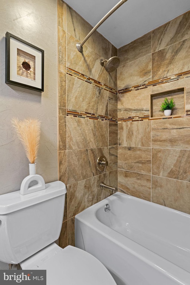 bathroom with toilet and tiled shower / bath