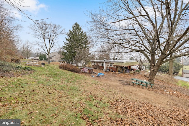 view of yard featuring an outbuilding, exterior structure, and driveway