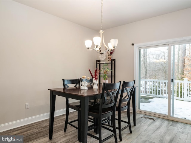 dining area featuring hardwood / wood-style floors and a chandelier