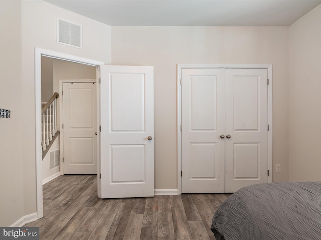 bedroom featuring wood-type flooring and a closet