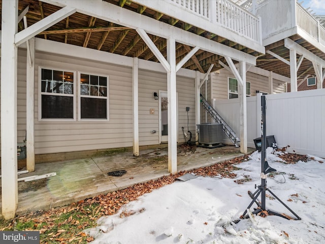 snow covered patio featuring central air condition unit