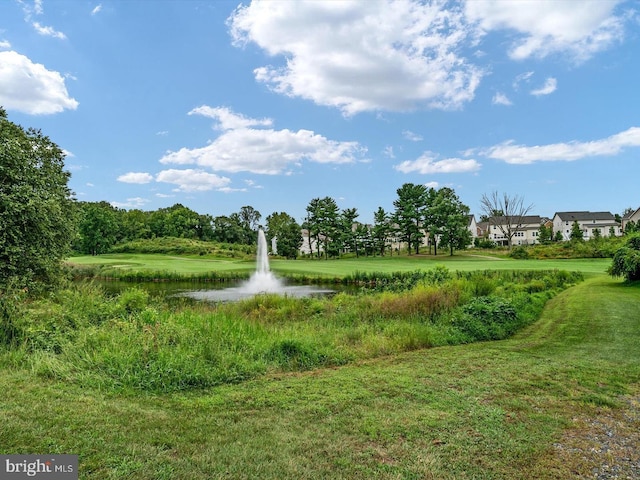 surrounding community with a yard and a water view