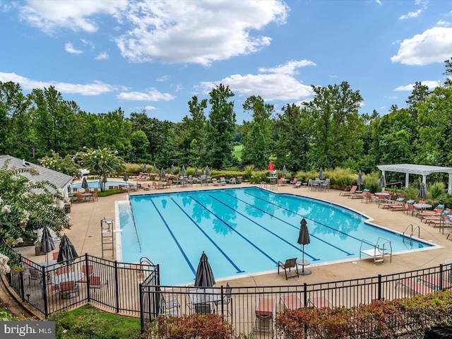 view of swimming pool with a patio and a pergola