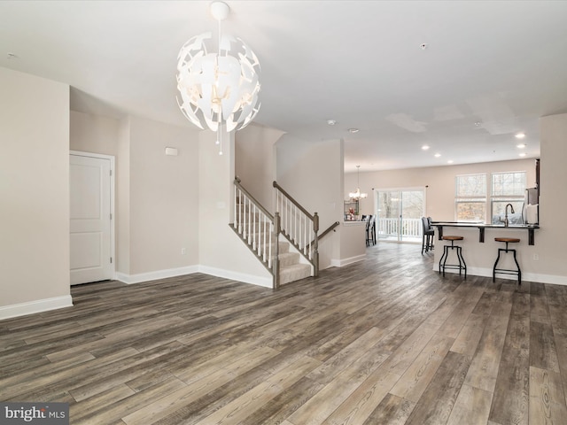 living room featuring wood-type flooring, sink, and a notable chandelier