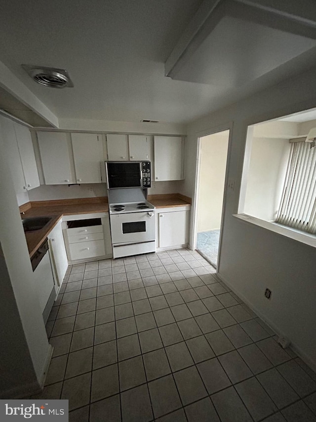 kitchen featuring sink, light tile patterned floors, white cabinets, and white appliances