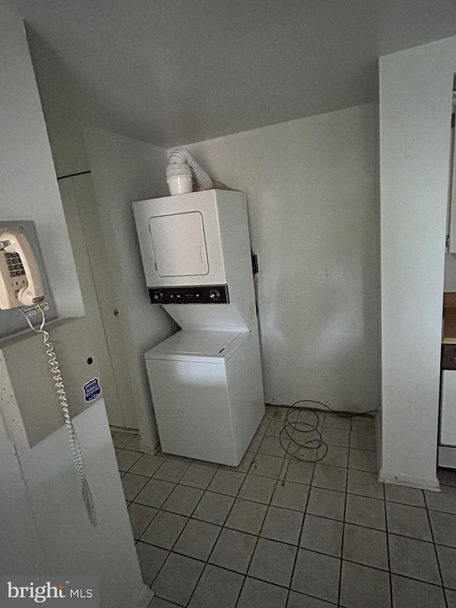 washroom featuring stacked washer and dryer and light tile patterned floors