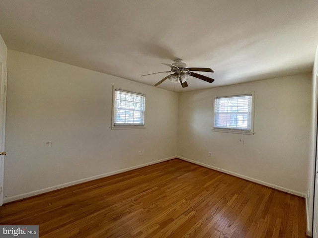 empty room featuring ceiling fan, wood-type flooring, and a healthy amount of sunlight