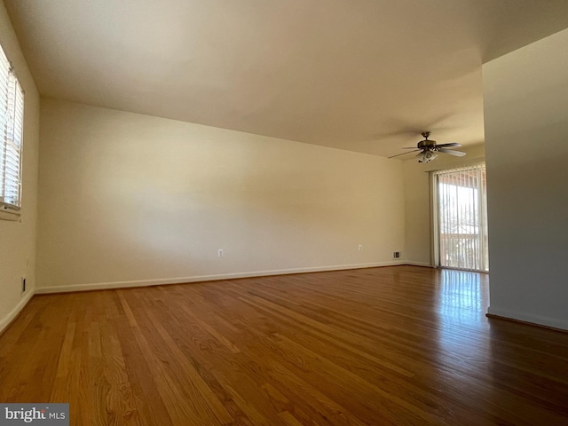 empty room with ceiling fan and dark hardwood / wood-style floors