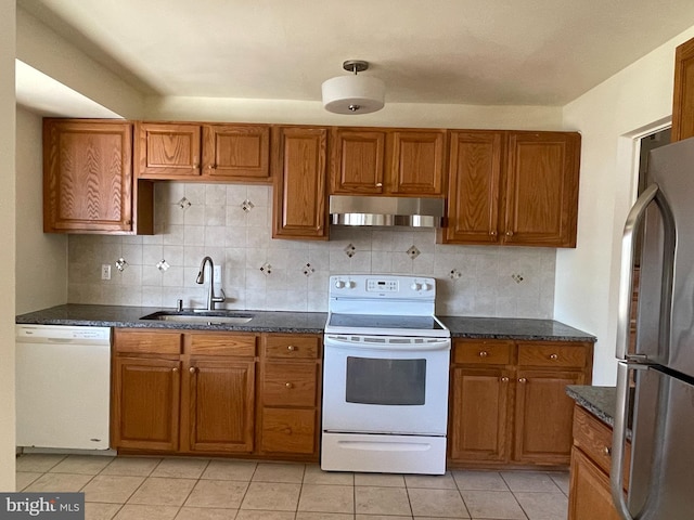 kitchen featuring light tile patterned floors, backsplash, sink, and white appliances