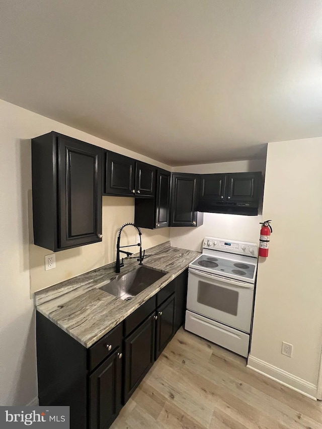 kitchen with light stone countertops, electric range, light hardwood / wood-style floors, and sink