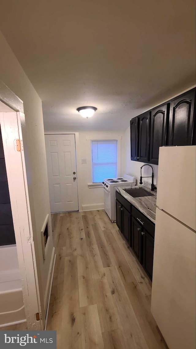 kitchen featuring sink, white appliances, and light hardwood / wood-style flooring