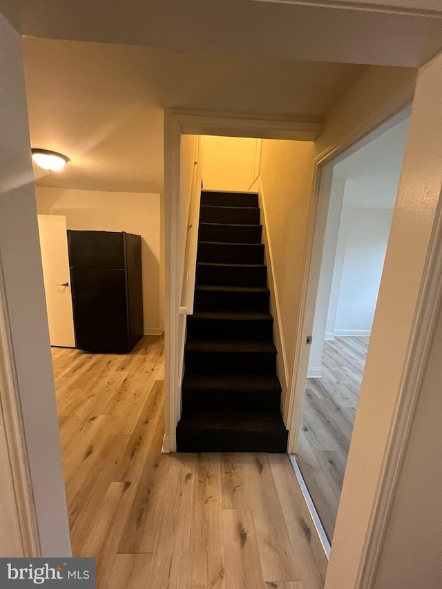 stairs featuring hardwood / wood-style floors