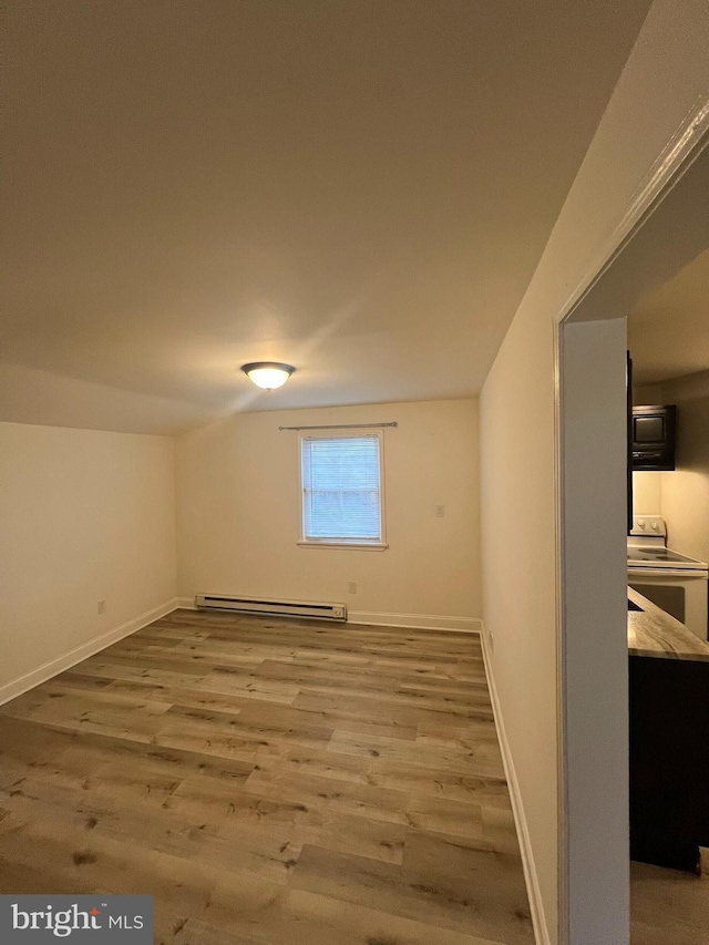 additional living space featuring wood-type flooring and baseboard heating