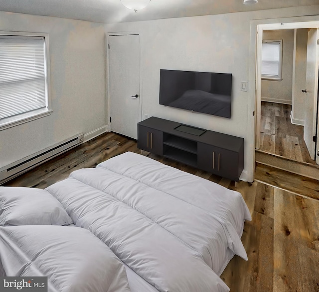 bedroom with baseboard heating and dark hardwood / wood-style flooring