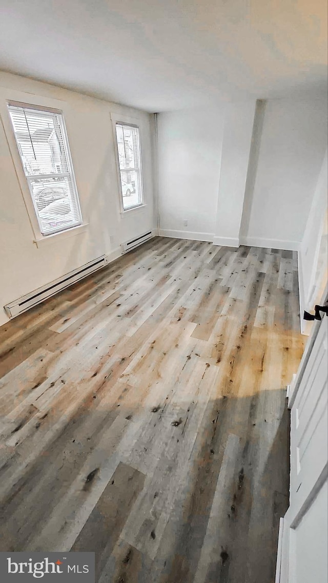 interior space with light hardwood / wood-style floors and a baseboard heating unit