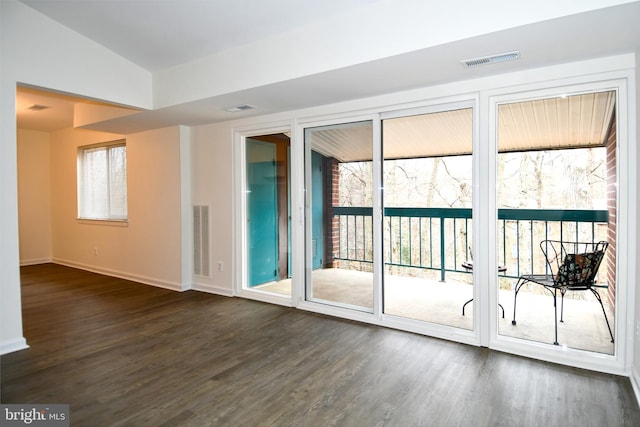 doorway featuring dark wood-style flooring, visible vents, and baseboards