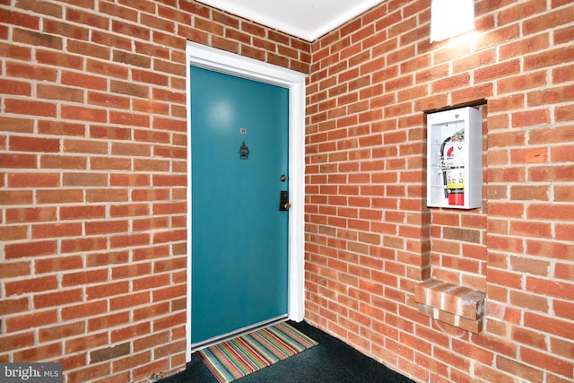 entrance to property featuring brick siding