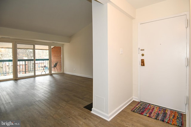 entrance foyer featuring baseboards, vaulted ceiling, and wood finished floors