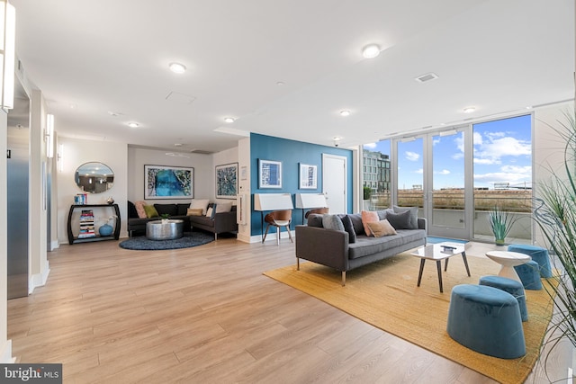 living room with light hardwood / wood-style floors and floor to ceiling windows