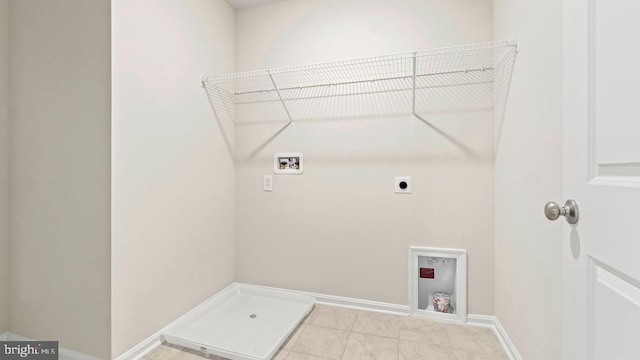 laundry area with hookup for an electric dryer, hookup for a washing machine, and light tile patterned floors