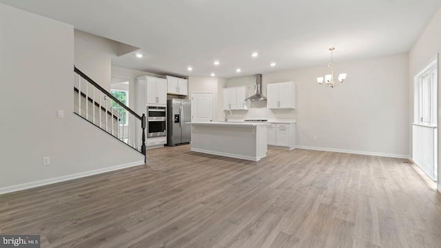 kitchen with white cabinetry, a kitchen island with sink, light hardwood / wood-style flooring, and stainless steel appliances