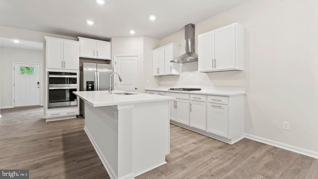 800 Long Meadow Dr, Fredericksburg, VA 22406 - kitchen with wall chimney range hood, stainless steel appliances, light wood-style floors, white cabinetry, and recessed lighting