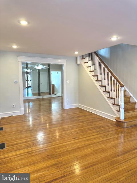 unfurnished living room with ceiling fan and wood-type flooring