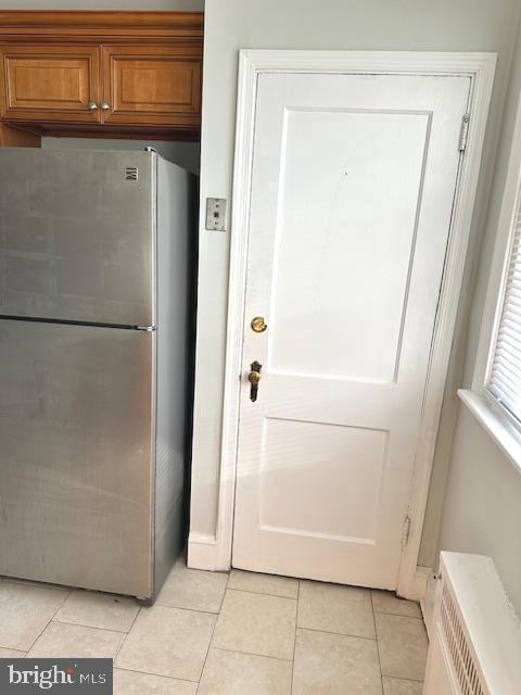 kitchen with stainless steel refrigerator and light tile patterned floors