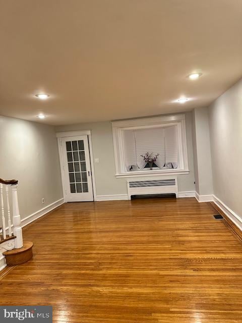 unfurnished living room featuring light hardwood / wood-style flooring and radiator