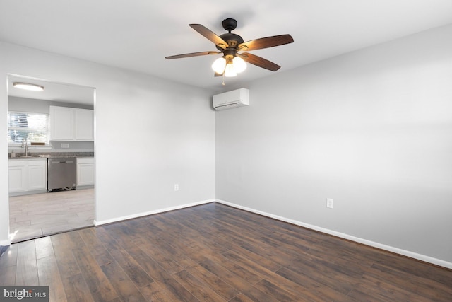 empty room with a wall mounted air conditioner, ceiling fan, light hardwood / wood-style floors, and sink