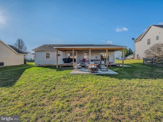 back of house featuring central AC, a yard, a patio, and an outdoor living space with a fire pit