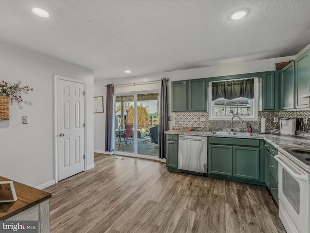 kitchen featuring green cabinets, electric stove, sink, stainless steel dishwasher, and hardwood / wood-style flooring