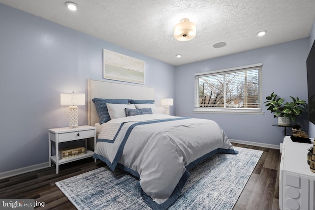 bedroom featuring a textured ceiling and dark hardwood / wood-style floors