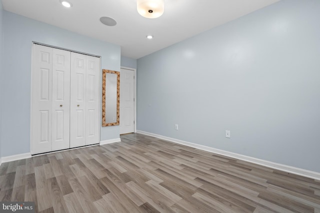 unfurnished bedroom with a closet and light hardwood / wood-style floors